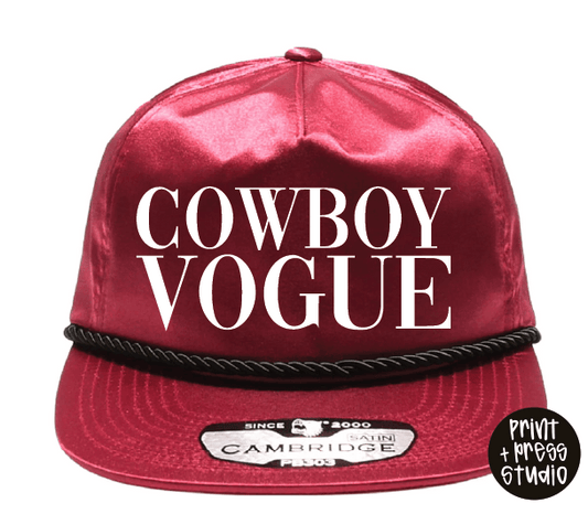 Red satin cap with 'Cowboy Vogue' text and Cambridge logo on a white background